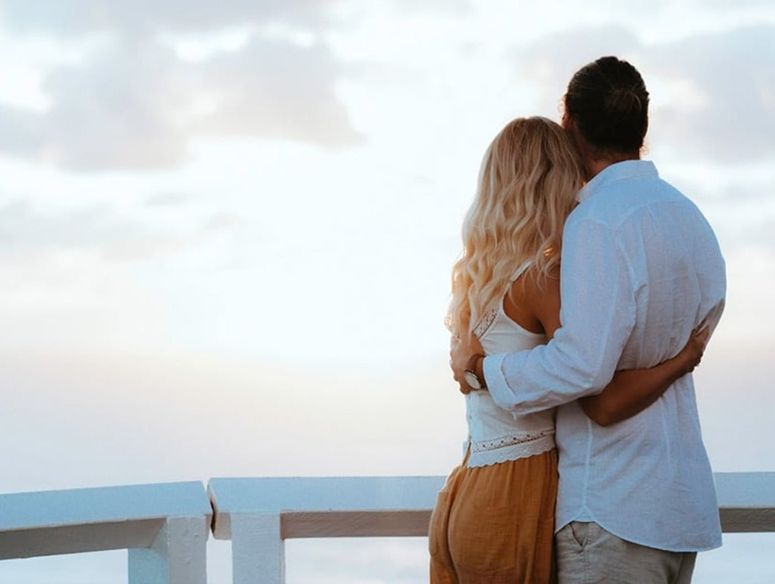 A couple hugging and looking at the view at Cape Byron